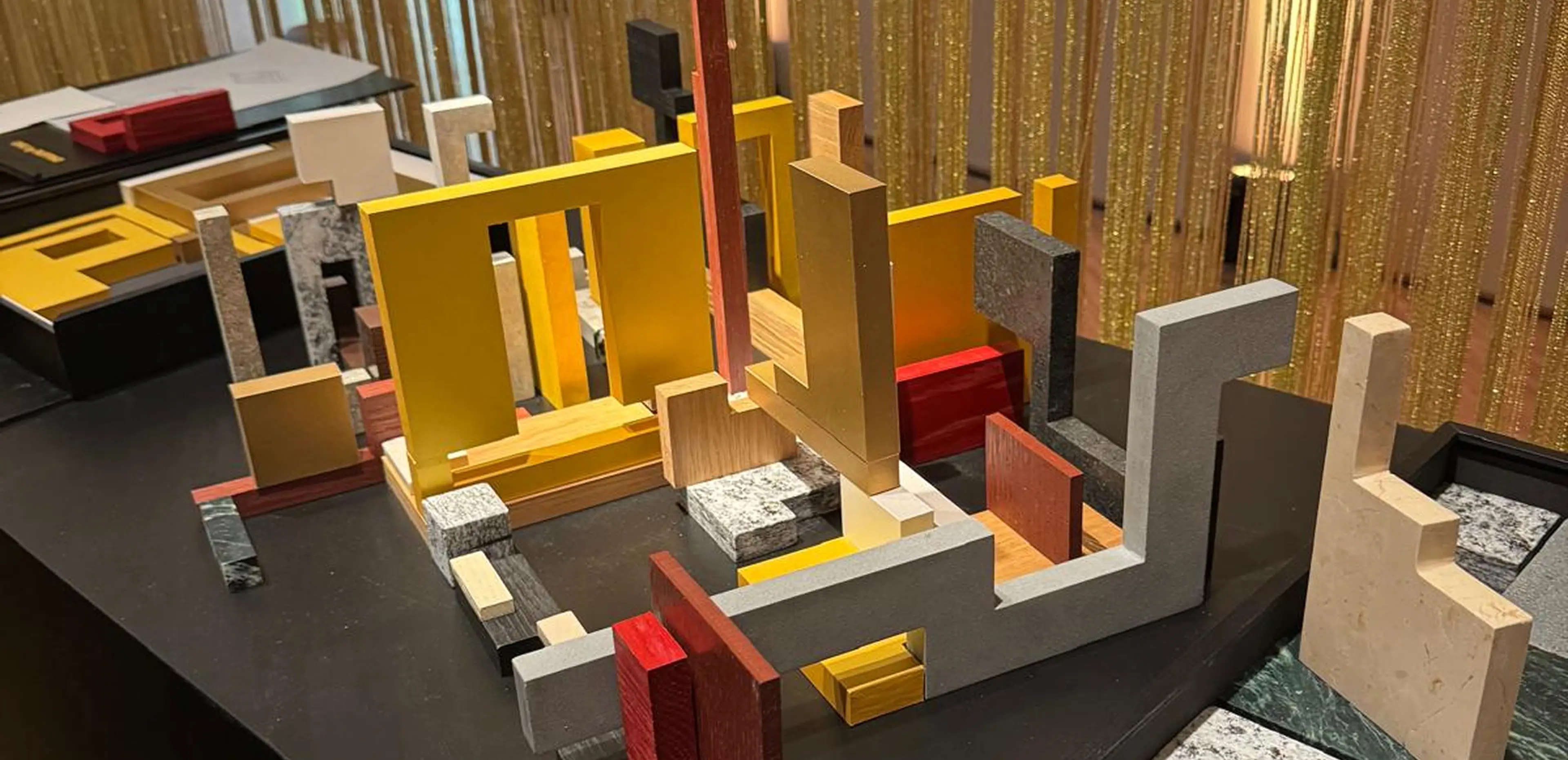 Installazione artistica Forme di Dialogo di Uros Mihic alla Triennale di Milano 2025 - sculture modulari in Verde Alpi, Serizzo, Grigio Alpi, Pietra Lavica, Quarzite Grigia e Botticino con legno e carta, lavorazione Trapattoni Marmi