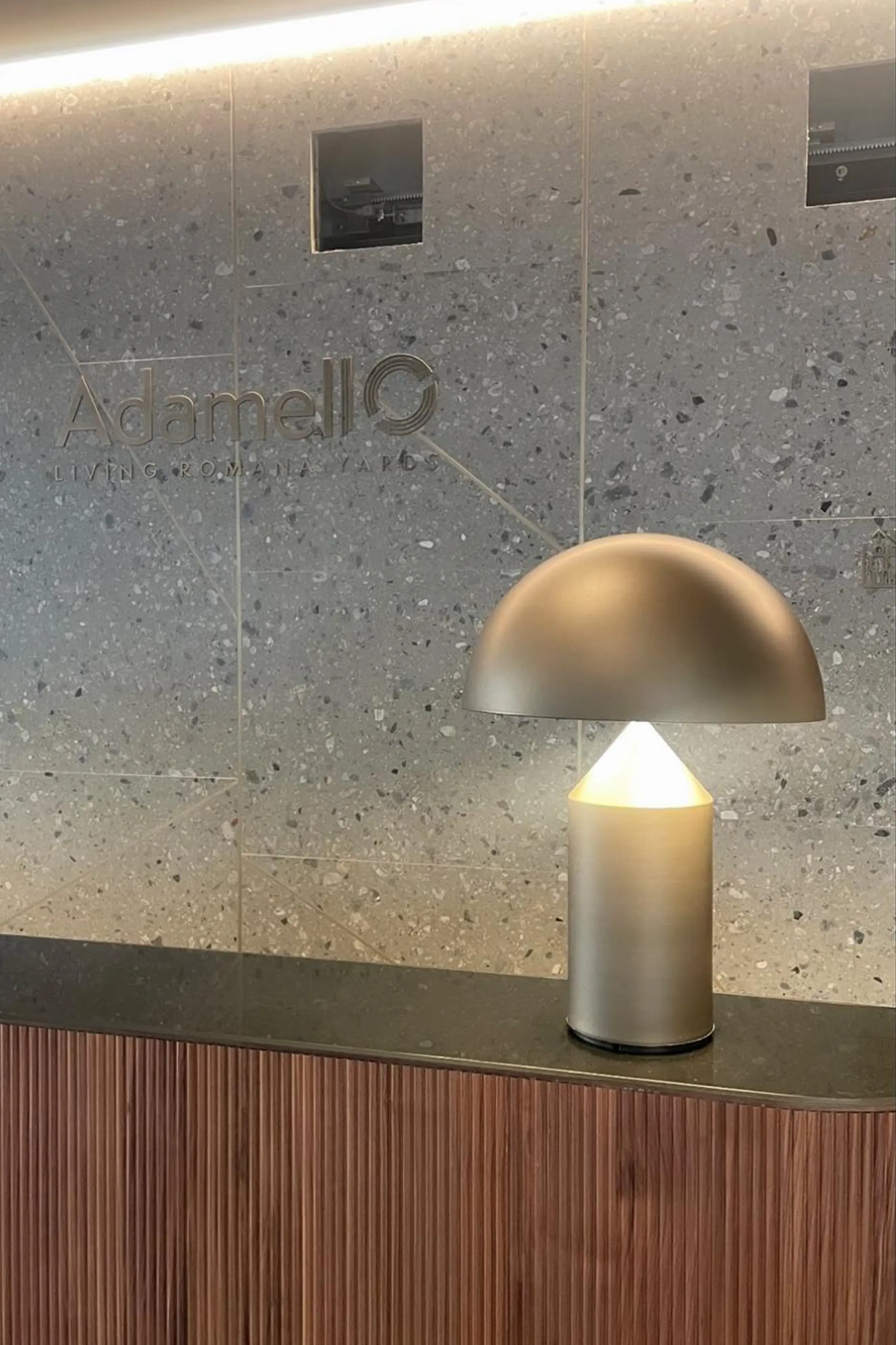 Dettaglio della parete a casellario in Agglotech SB130 Aggloceppo levigato con inserti in ottone e logo Adamello Living Romana Yards inciso - hall d'ingresso del complesso residenziale di lusso, Trapattoni Marmi Milano