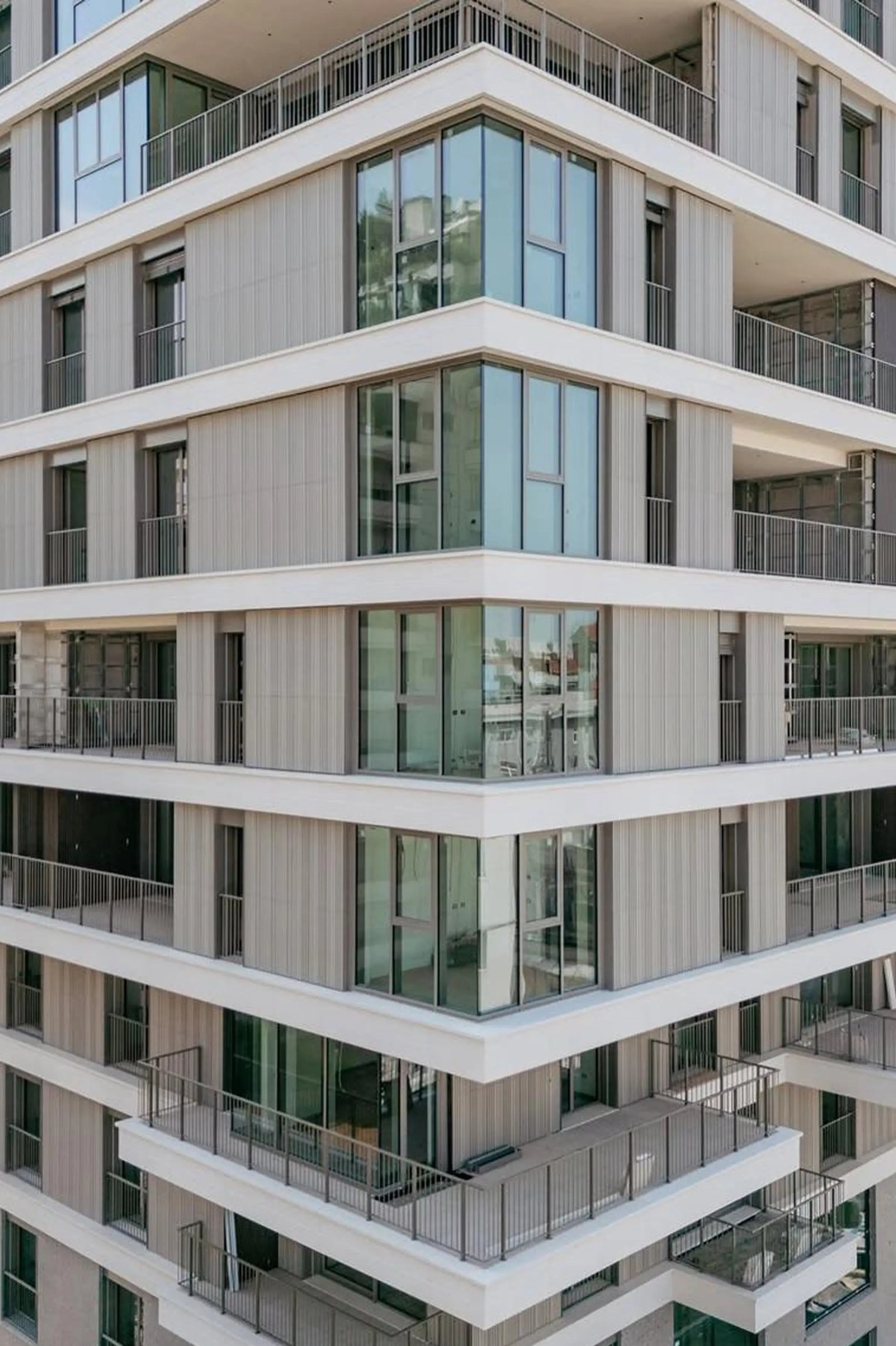 Dettaglio della facciata della Torre Adamello Living Romana Yards a Milano: balconi aggettanti con parapetti in acciaio, rivestimento verticale e pannelli in Agglotech SB130 Aggloceppo levigato - Trapattoni Marmi, Milano 2024-2025