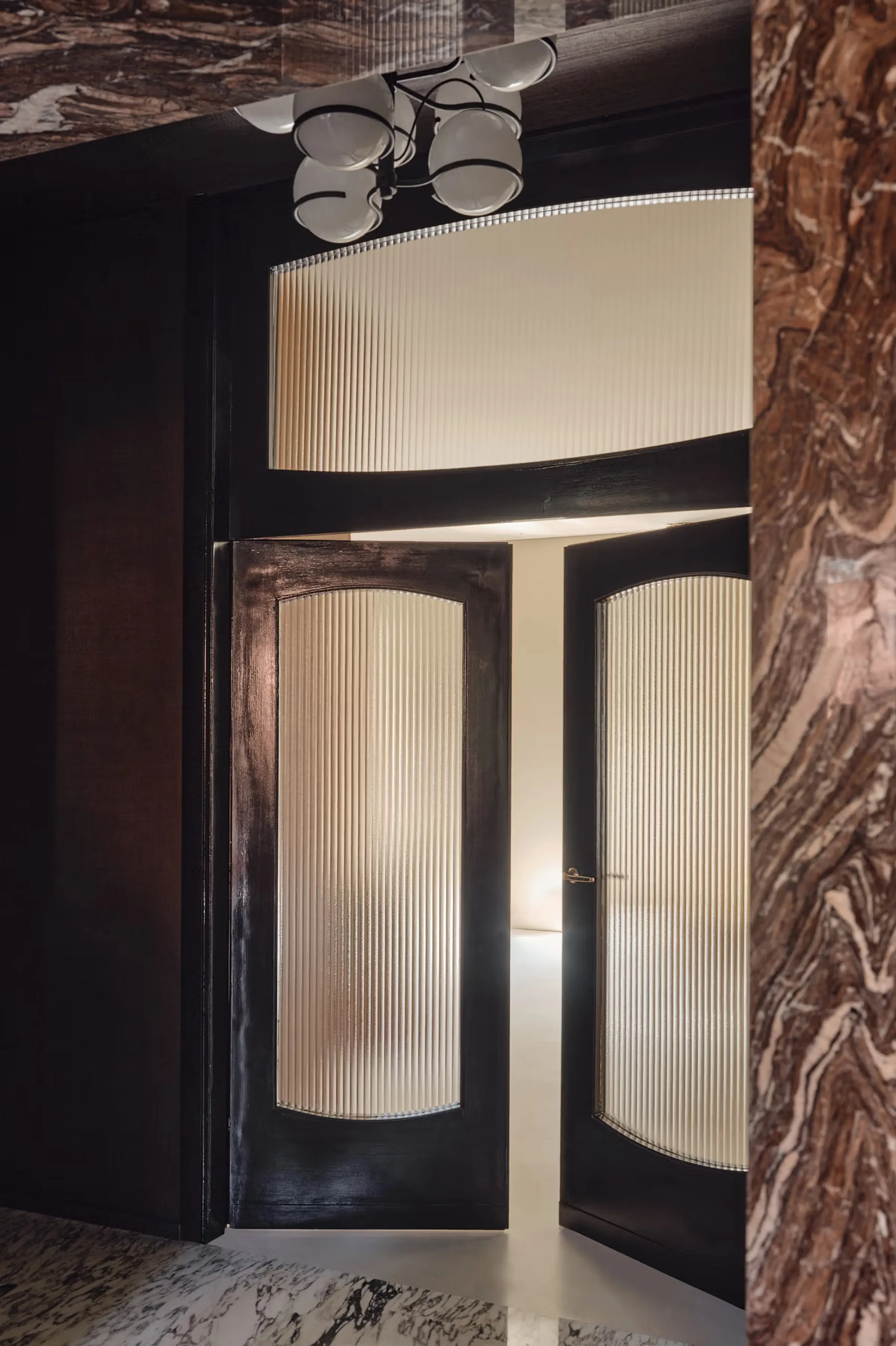 Dettaglio del portale d'ingresso in Cipollino rosso-viola lucido con venature rosse e bordeaux, porte originali con vetri rigati e pavimento in marmo bianco - dimora privata alla Conca del Naviglio di Milano, progetto LC Atelier x Trapattoni Marmi