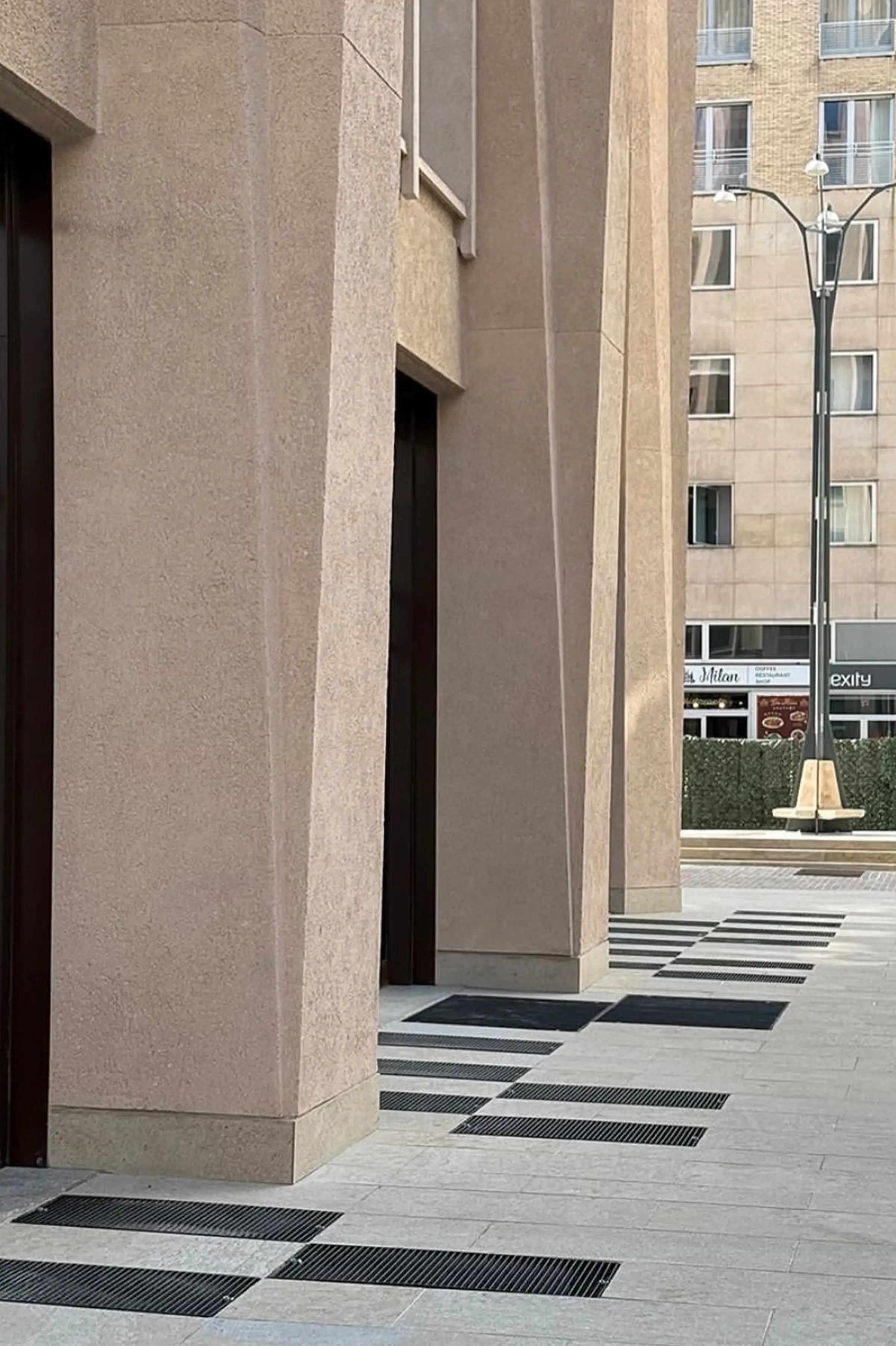 Basamento della Torre Velasca con rivestimento in Trachite Euganea e pavimentazione esterna in pietra naturale a corsi - restauro Piazza Velasca posa Trapattoni Marmi