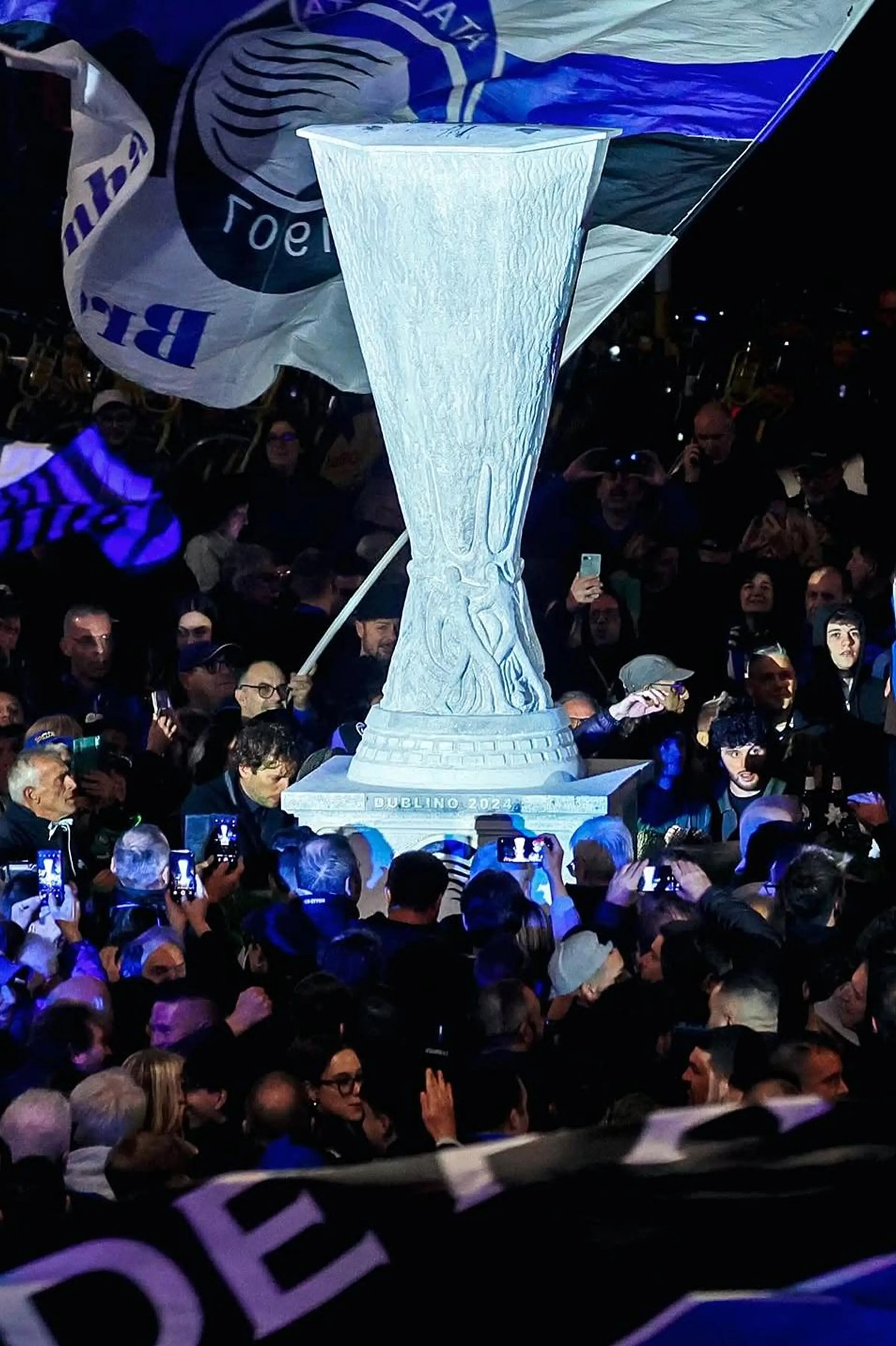 Scultura in Pietra di Vicenza della Coppa UEFA Europa League circondata dai tifosi dell'Atalanta durante l'inaugurazione notturna a Bergamo - realizzazione Trapattoni Marmi