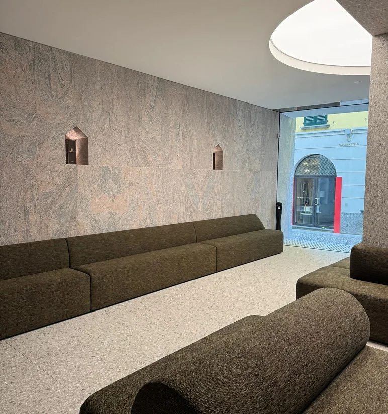 Lobby dello showroom in Via Fiori Chiari a Milano con parete in Granito Juparanà Rosa a macchia aperta e pavimento in Agglotech SB220 Giudecca sabbiato e spazzolato - posa Trapattoni Marmi