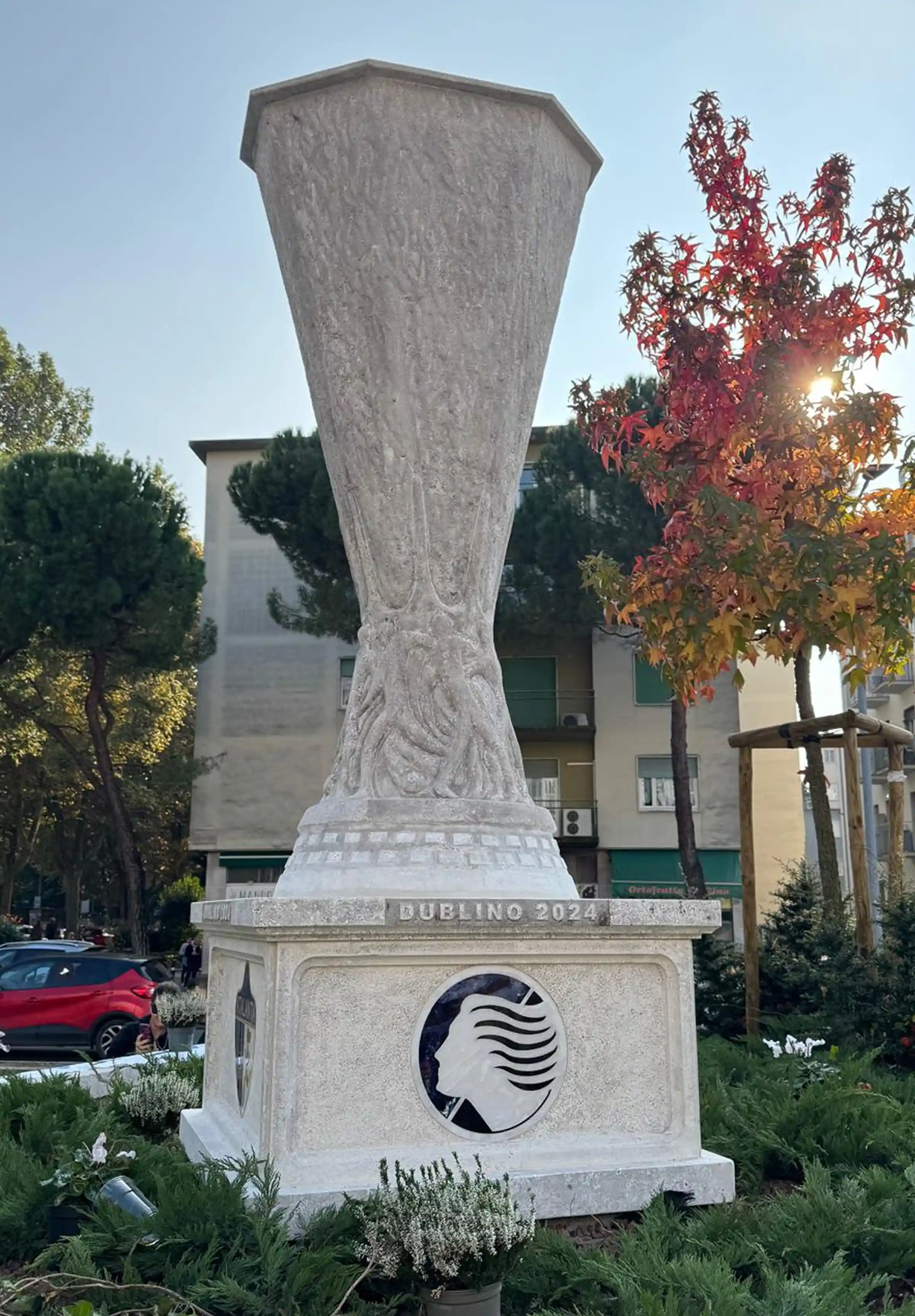 Scultura in Pietra di Vicenza alta oltre 2,50 metri con intarsi in Azul Macauba, Sodalite, Giallo Siena e Bianco Thassos raffigurante la Coppa UEFA Europa League 2024 davanti allo Stadio Comunale di Bergamo - Trapattoni Marmi
